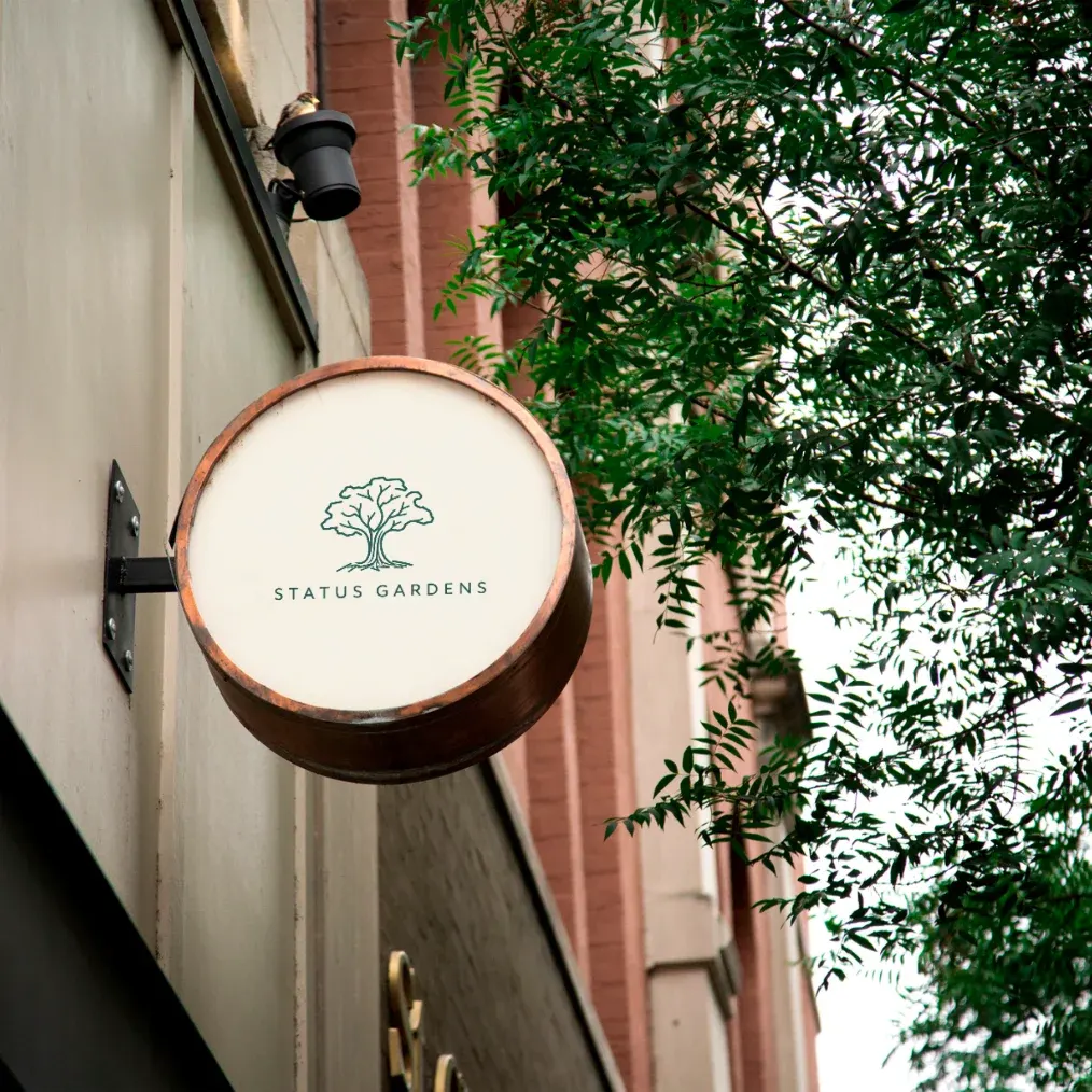 Status Gardens tree logo on a round garden sign